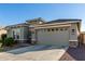 Two-car garage and neutral-toned exterior with desert landscaping at 18865 W Mescal St, Surprise, AZ 85388