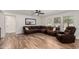 Comfortable living room with a large sectional sofa, wood-look flooring, and natural light, ideal for relaxing and entertaining at 19641 E Emperor Blvd, Queen Creek, AZ 85142