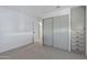 Bright bedroom with mirrored closet doors and grey carpet at 201 S Greenfield Rd # 205, Mesa, AZ 85206