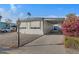 Mobile home exterior with carport, landscaping, and flowering bushes at 201 S Greenfield Rd # 205, Mesa, AZ 85206