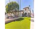 Community clubhouse featuring stucco walls, beautiful landscaping, and green grass, welcoming residents and guests at 205 S Higley Rd # 32, Mesa, AZ 85206