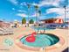 Community pool and hot tub area with lounge chairs and palm trees on a sunny day at 205 S Higley Rd # 32, Mesa, AZ 85206