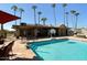 A community pool with palm trees, a covered seating area and amenities, enhancing the outdoor experience at 205 S Higley Rd # 32, Mesa, AZ 85206