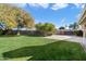 Large backyard with grassy area, mature trees, and patio at 24444 N 40Th Ln, Glendale, AZ 85310