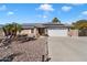 House exterior featuring solar panels, a white garage door, and desert landscaping at 24444 N 40Th Ln, Glendale, AZ 85310