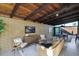 Mid-century modern living room with wood beamed ceiling, brick wall, and comfortable seating at 4216 N 38Th St # C, Phoenix, AZ 85018