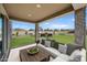 Cozy covered patio featuring an outdoor seating area with a view of the well-manicured backyard at 779 S La Mesa Ct, Casa Grande, AZ 85122