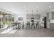 Modern kitchen with light gray cabinetry, stainless steel appliances, a white center island, and dining area at 779 S La Mesa Ct, Casa Grande, AZ 85122