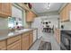 Bright kitchen with light wood cabinets, stainless steel appliances, and view to dining area at 7960 E Madero Ave, Mesa, AZ 85209