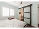 Bedroom view with bed, and a sliding barn door leading to the bathroom at 813 E Glendale Ave, Phoenix, AZ 85020