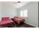 Cozy bedroom features two twin beds, ceiling fan, and a window with plantation shutters at 813 E Glendale Ave, Phoenix, AZ 85020