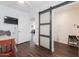 Bedroom with a sliding barn door leading to a bathroom with sink and shoe rack at 813 E Glendale Ave, Phoenix, AZ 85020