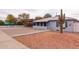 An exterior view of a single-story home with desert landscaping and a covered carport at 813 E Glendale Ave, Phoenix, AZ 85020