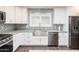 Updated kitchen showcasing white cabinetry, stainless appliances and mosaic backsplash at 813 E Glendale Ave, Phoenix, AZ 85020