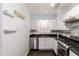 Well-lit kitchen featuring stainless steel appliances, white cabinets, and dark countertops at 813 E Glendale Ave, Phoenix, AZ 85020