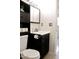 Clean bathroom with dark vanity, toilet and shelving at 8213 S 25Th St, Phoenix, AZ 85042