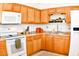 Kitchen featuring light wood cabinets, white appliances, and a tiled floor at 8213 S 25Th St, Phoenix, AZ 85042