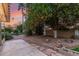 Expansive backyard area featuring mature trees, grass, gravel, and a patio, all bathed in the warm colors of sunset at 9734 N 105Th Dr, Sun City, AZ 85351