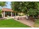 Landscaped backyard with grass, gravel, and mature orange tree at 9734 N 105Th Dr, Sun City, AZ 85351