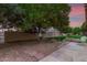 Spacious backyard featuring a gravel area, stone pavers, mature trees, and grass at 9734 N 105Th Dr, Sun City, AZ 85351