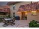 Outdoor patio featuring a dining table with seating for four, a grill, and lush landscaping at 9734 N 105Th Dr, Sun City, AZ 85351