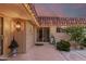 Outdoor patio area offering access to the home, accented by an ornate sconce, lush greenery, and a tile roof at 9734 N 105Th Dr, Sun City, AZ 85351