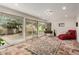 Sunroom with tiled floors, sliding glass doors, and a red chaise lounge at 9734 N 105Th Dr, Sun City, AZ 85351