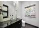 Chic powder room with glass bowl sink, and black vanity, complemented by modern lighting and artwork at 10878 E Sundance Trl, Scottsdale, AZ 85262