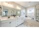 Bright bathroom showcasing a double vanity, a large mirror and a soaking tub with marble surround at 12527 W Sierra Vista Ct, Glendale, AZ 85307