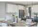 Dining room with white chairs, table setting, pendant lights, and open view to the kitchen at 12527 W Sierra Vista Ct, Glendale, AZ 85307