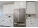 Bright kitchen featuring stainless steel refrigerator and white cabinets with modern hardware at 12527 W Sierra Vista Ct, Glendale, AZ 85307