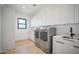 Modern laundry room with washer, dryer, and sink at 12808 E Harper Dr, Scottsdale, AZ 85255