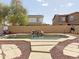 Backyard pool featuring rock waterfall, stone path, and a basketball hoop at 13779 W Mauna Loa Ln, Surprise, AZ 85379