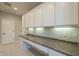 Bright laundry room with white cabinets and granite countertops at 1620 E Azafran Trl, Queen Creek, AZ 85140