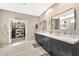 Double vanity bathroom with dark cabinetry and marble flooring at 2415 W Weatherby Way, Chandler, AZ 85286