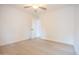 Bright bedroom with hardwood floors, a ceiling fan, white walls, and an entry door at 342 E Orangewood Ave, Phoenix, AZ 85020