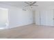 Large bedroom with sleek white doors, light wood floors and a ceiling fan at 342 E Orangewood Ave, Phoenix, AZ 85020