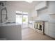 Modern kitchen with stainless steel appliances, white cabinetry, and a view of the backyard at 342 E Orangewood Ave, Phoenix, AZ 85020