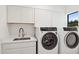 Well-equipped laundry room featuring modern appliances, ample cabinetry, and a practical sink area at 342 E Orangewood Ave, Phoenix, AZ 85020