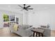Well-lit living room with ceiling fan, wood floors, gray sofa and chair, with views to outdoor spaces at 342 E Orangewood Ave, Phoenix, AZ 85020