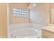 Bathroom soaking tub with glass block window and tile flooring at 3799 N 154Th Dr, Goodyear, AZ 85395