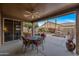 Covered patio with an outdoor dining set, ceiling fan, and view of the landscaped backyard at 3799 N 154Th Dr, Goodyear, AZ 85395