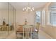 Bright dining room with large table, chandelier, mirrored wall, and neutral colors at 3799 N 154Th Dr, Goodyear, AZ 85395