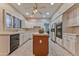 Bright kitchen with island, white cabinetry, built-in appliances and light tile floors at 3799 N 154Th Dr, Goodyear, AZ 85395