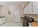 Laundry area with a front-loading washer and dryer, white cabinets, and a utility sink at 3799 N 154Th Dr, Goodyear, AZ 85395