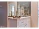 Wet bar with white tile countertop, mirrored backsplash, a sink, and glass shelves at 3799 N 154Th Dr, Goodyear, AZ 85395