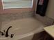 Bathroom with an oval soaking tub and marble-like tile accents at 400 W Wisteria Pl, Chandler, AZ 85248