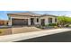 Tan colored house with a brown two car garage and nicely landscaped front yard at 6659 N 127Th Dr, Glendale, AZ 85307