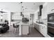 Modern kitchen with white cabinets and a large island with seating at 6659 N 127Th Dr, Glendale, AZ 85307