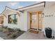 Inviting exterior featuring a light-colored facade, wood front door, and landscaping at 8437 E San Miguel Ave, Scottsdale, AZ 85250